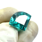 10.70 Ct Green Garnet gemstone held between three gloved fingers, fancy cut, eye-clean and certified